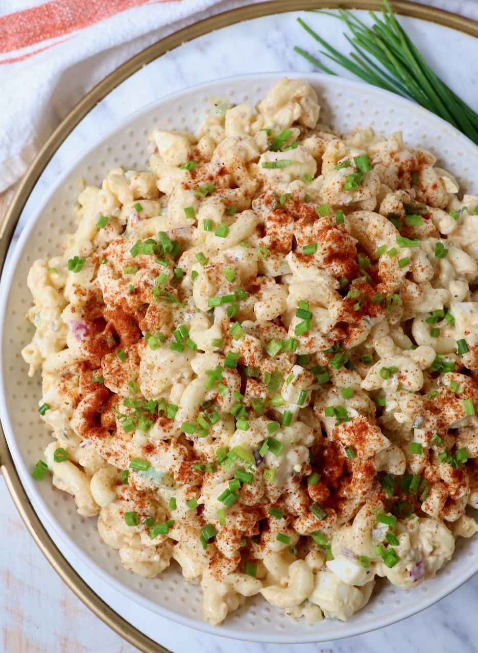 deviled egg pasta salad in bowl topped with paprika and chopped chives