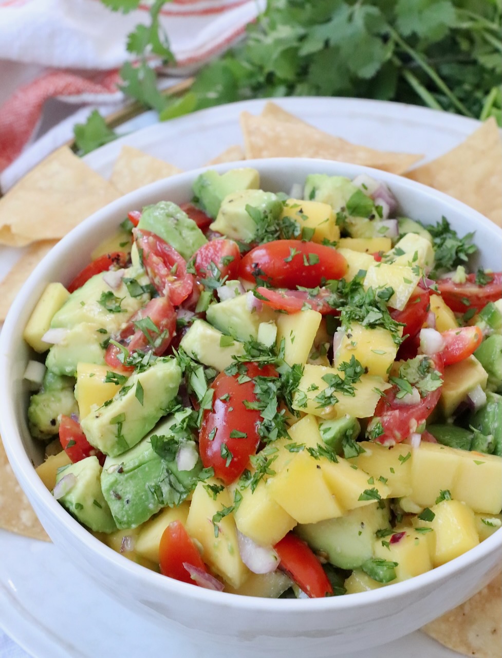mango avocado salsa in bowl on tray with tortilla chips