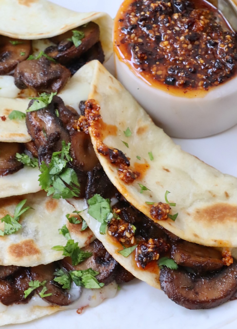 mushroom tacos on plate with a small bowl of salsa macha on the side