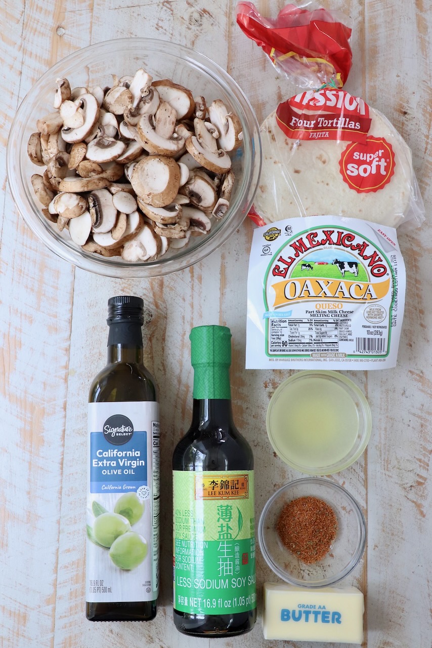 ingredients for mushroom tacos on white wood board