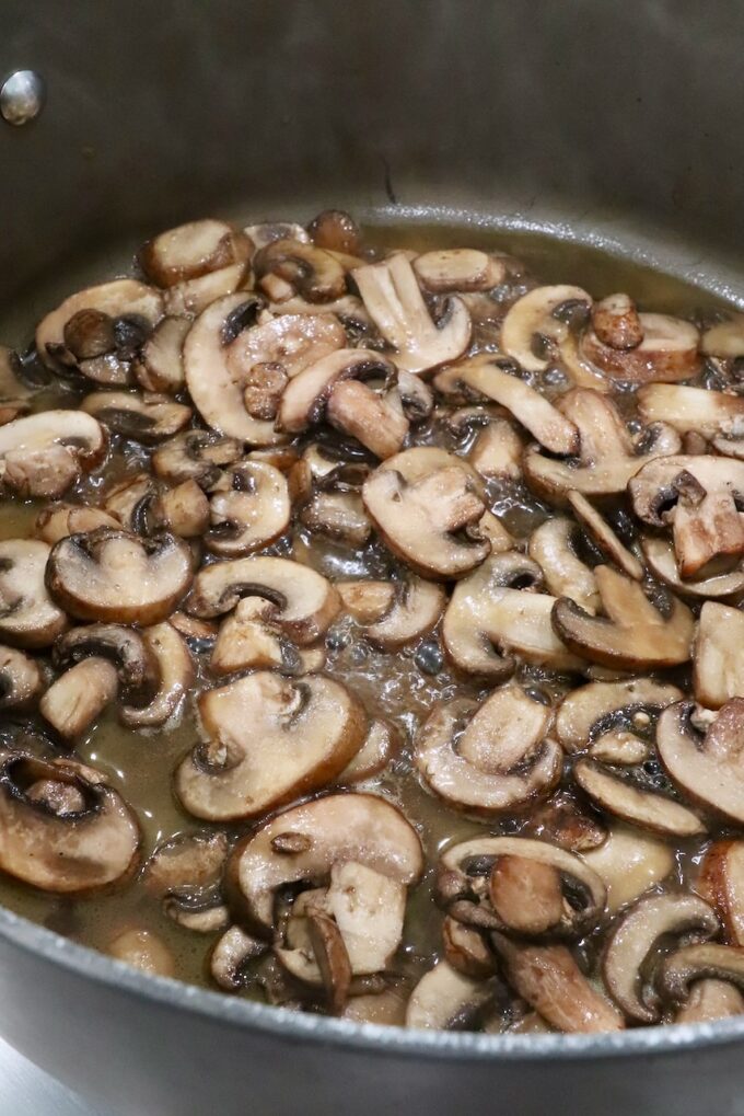 sliced mushrooms with broth in a large pot