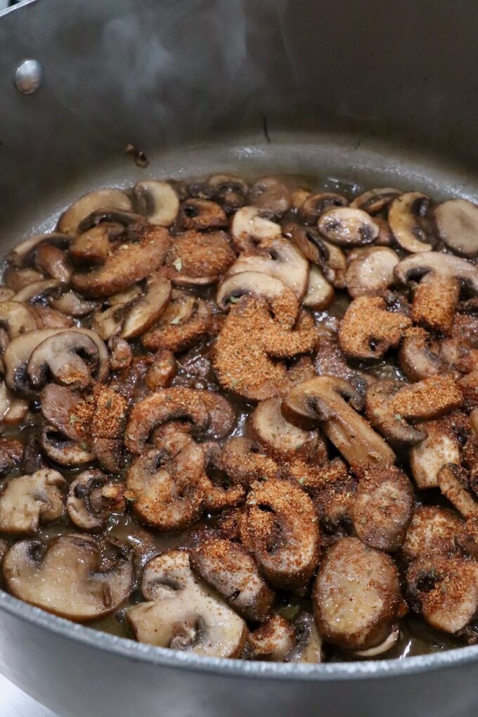 sliced mushrooms seasoned in a large pot