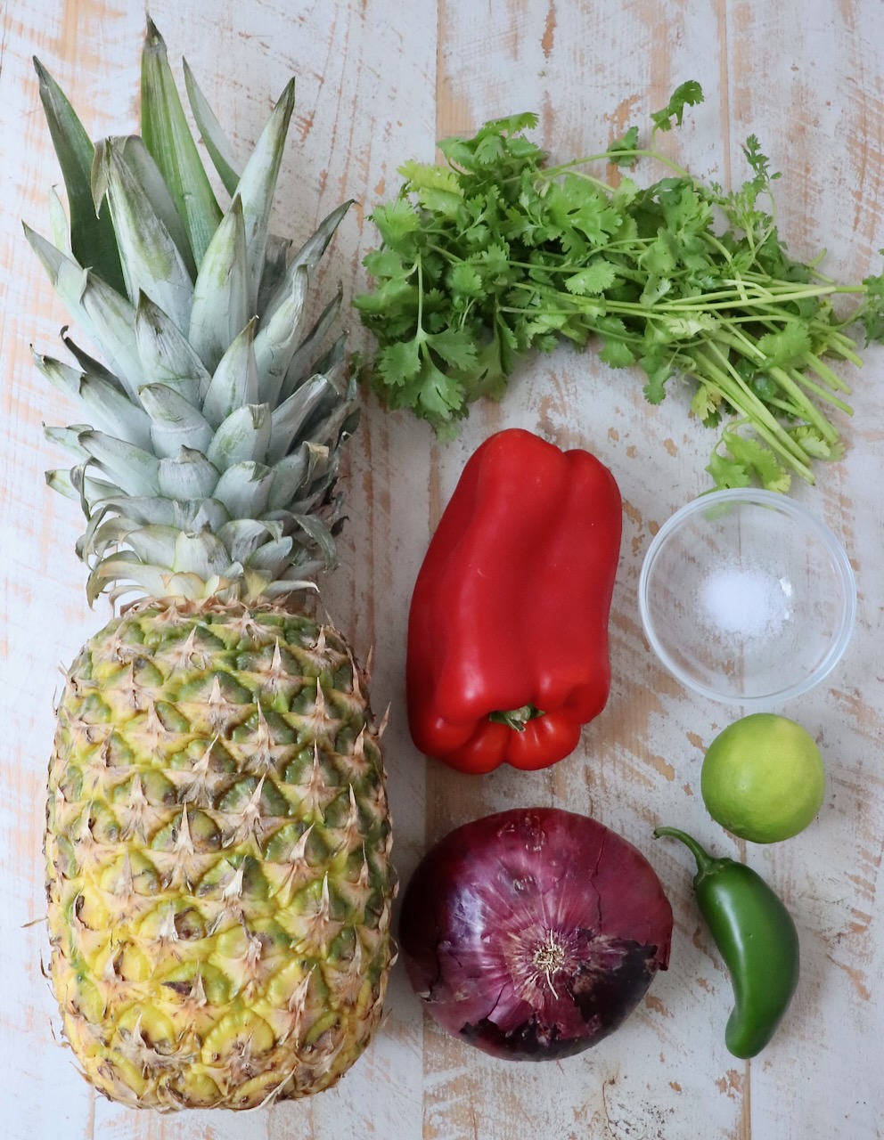 ingredients for pineapple salsa on white wood board