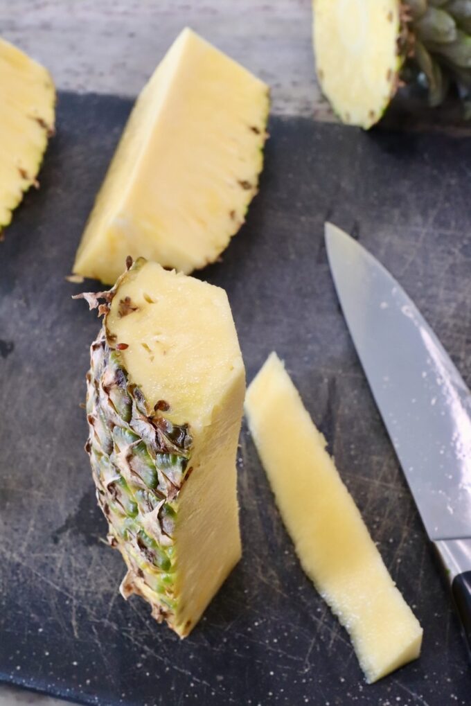 sliced pineapple on cutting board with the core removed