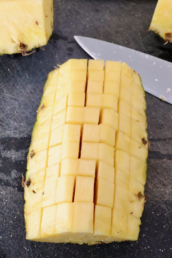 diced fresh pineapple on a cutting board with a knife