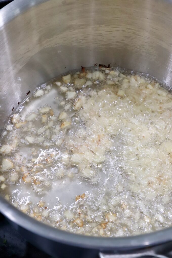 garlic cooking in oil in a saucepan