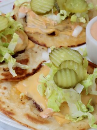 smash burger tacos on a plate with a small bowl of burger sauce on the side