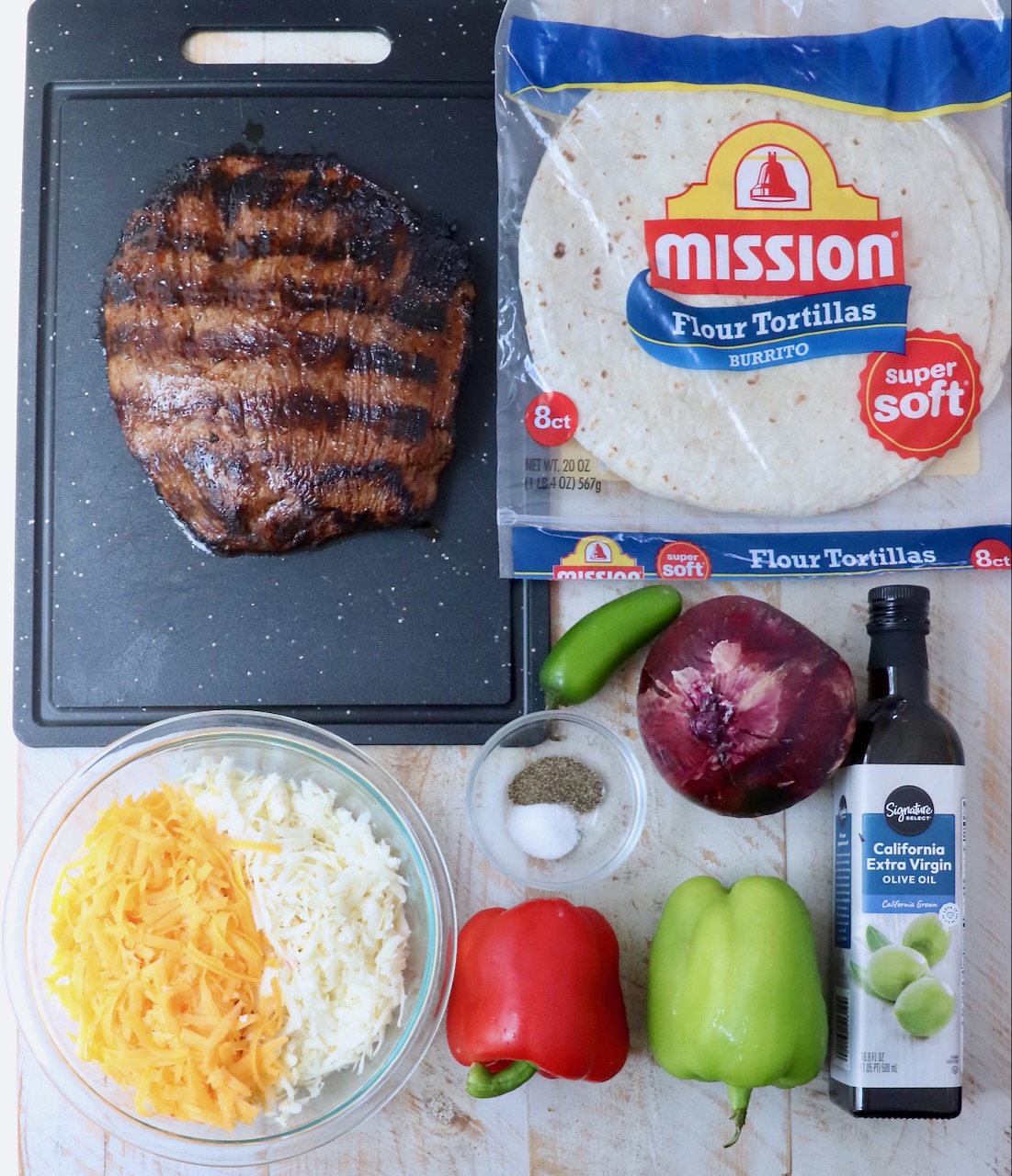 ingredients for steak quesadilla on white wood board