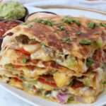 steak quesadilla cut into triangles and stacked up on a plate