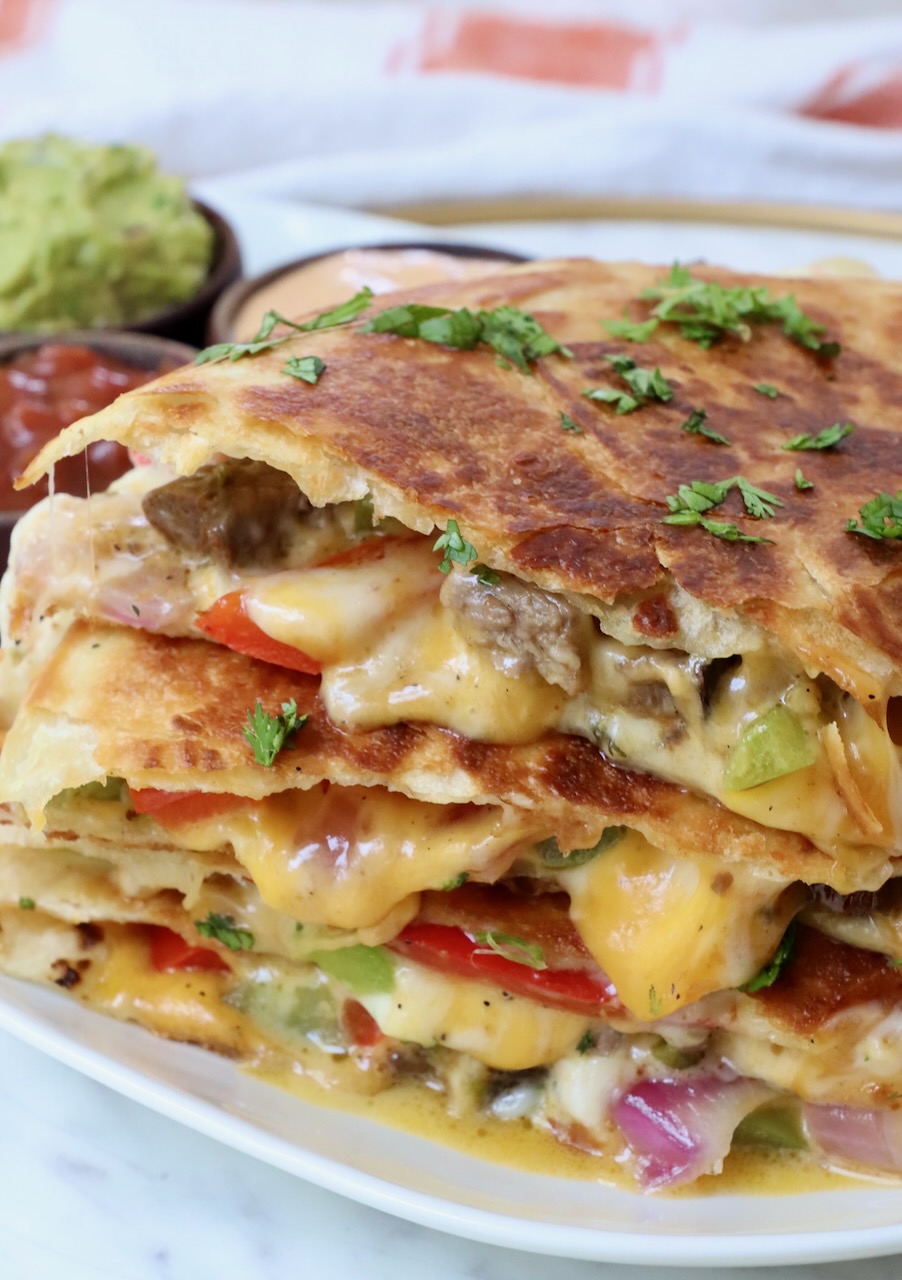 steak quesadilla cut into triangles stacked up on a plate