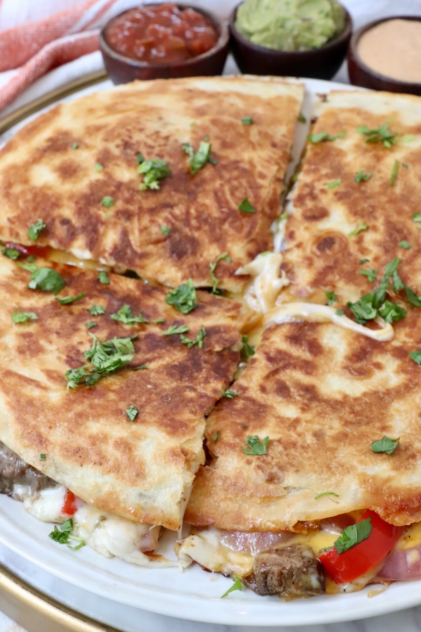 steak quesadilla cut into quarters on a plate