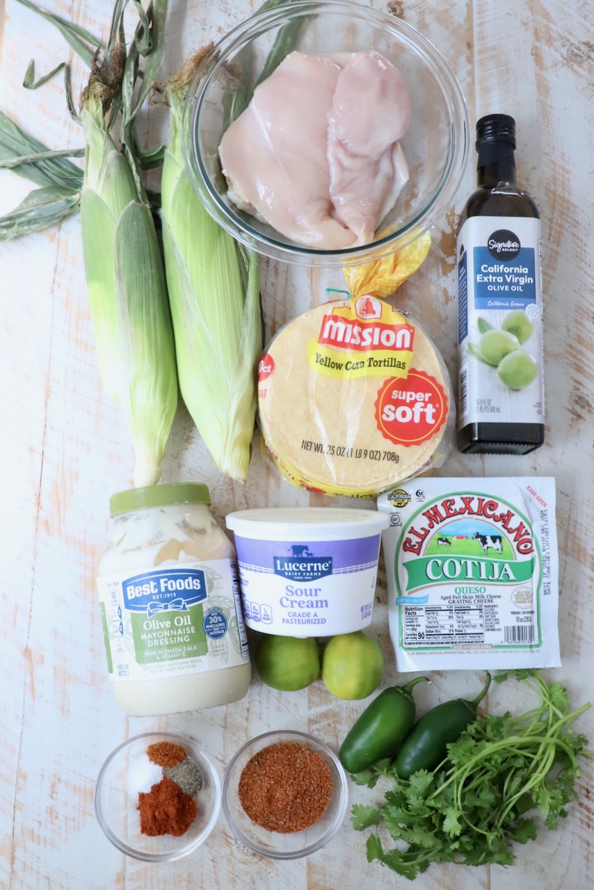 ingredients for chicken street corn tacos on white wood board