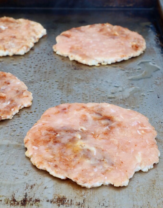 smashed chicken burger patties on a griddle