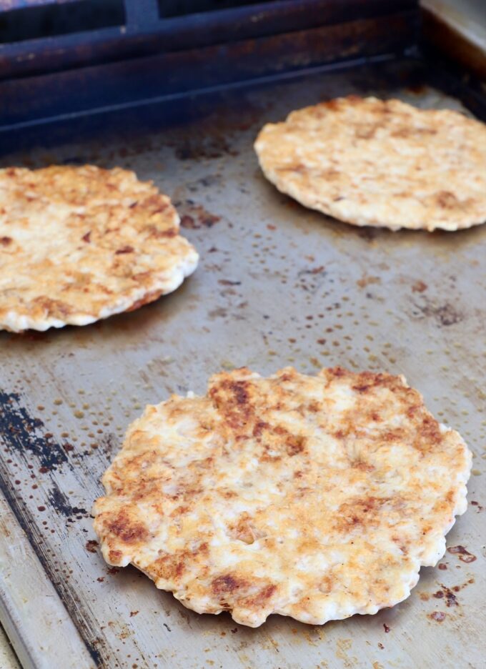 cooked, smashed chicken patties on a griddle