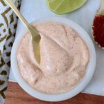 chili lime dressing in a white bowl with a gold spoon