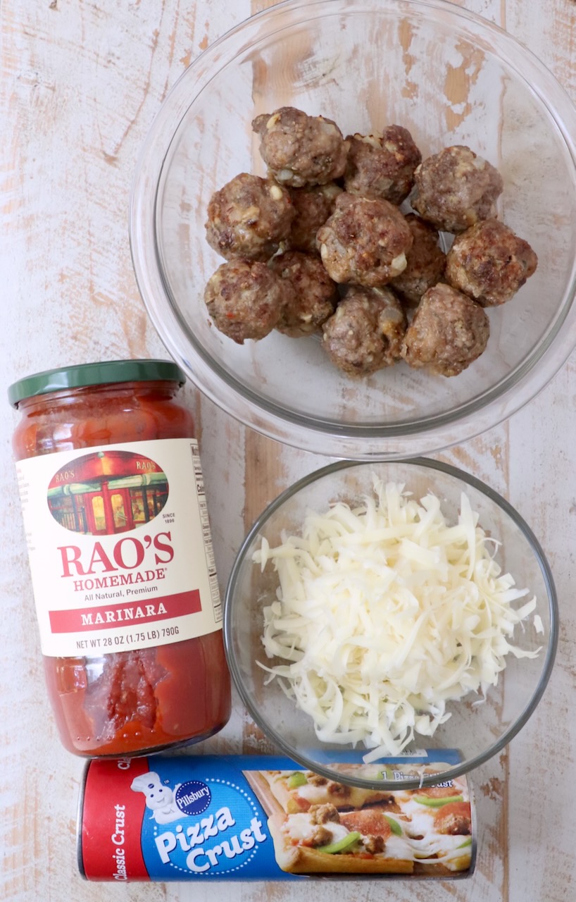 ingredients for meatball sub bites on a white wood board