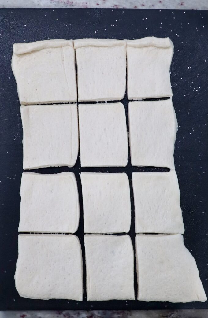 pizza dough on cutting board cut into small squares