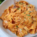 pasta tossed with creamy nduja sauce in bowl with fork