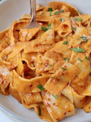 pasta tossed with creamy nduja sauce in bowl with fork