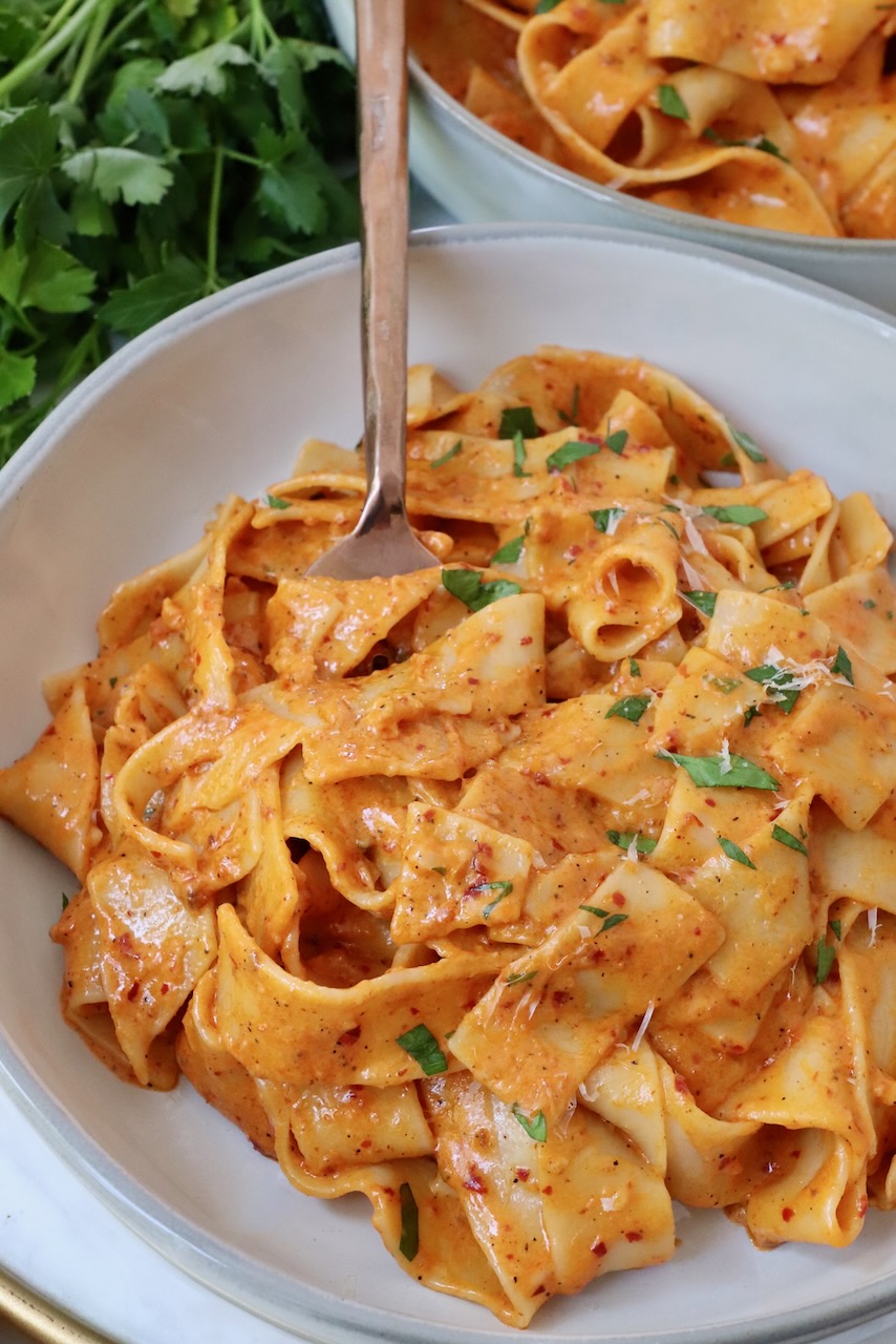 pappardelle pasta tossed with nduja sauce in bowl with fork