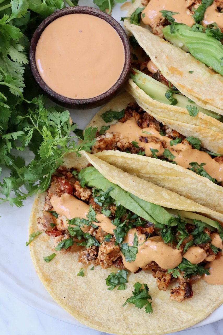 crumbled tofu tacos on plate topped with chipotle sauce