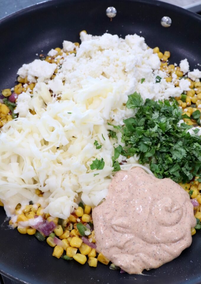 corn kernels, diced onions and jalapenos in a skillet with chili lime dressing, cilantro and cheese