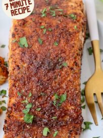 seasoned, cooked salmon filet on a plate with a fork