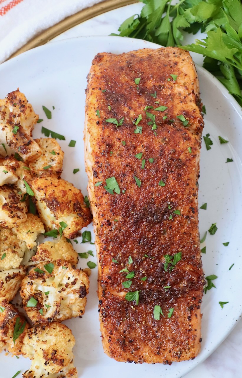 seasoned cooked salmon on plate with roasted cauliflower