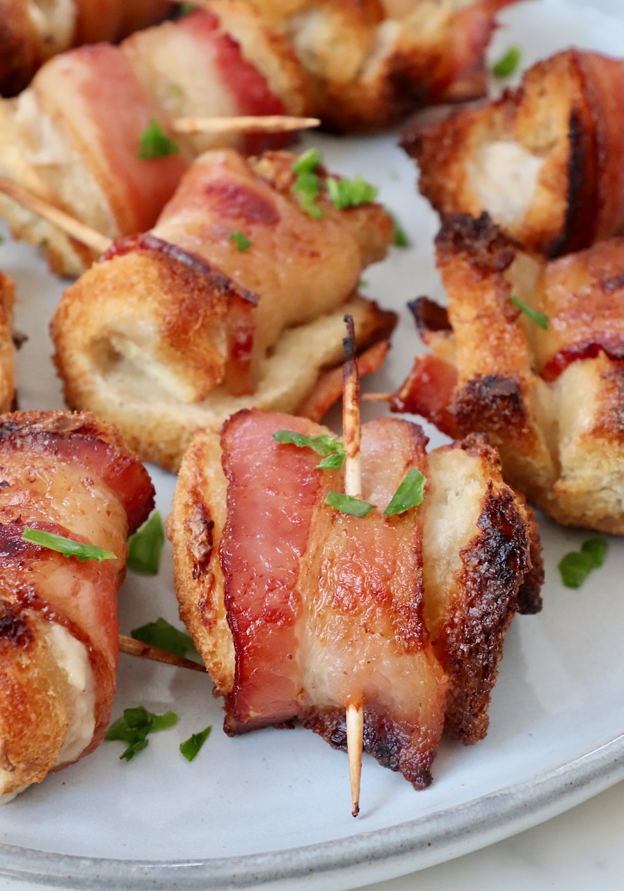 bacon roll-ups on a plate garnished with chopped parsley