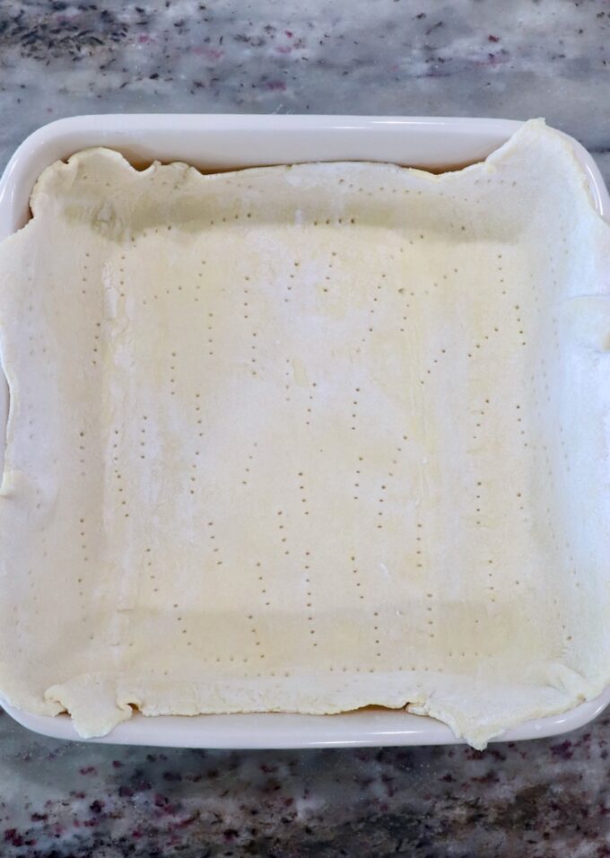 puff pastry dough pressed into a square baking dish