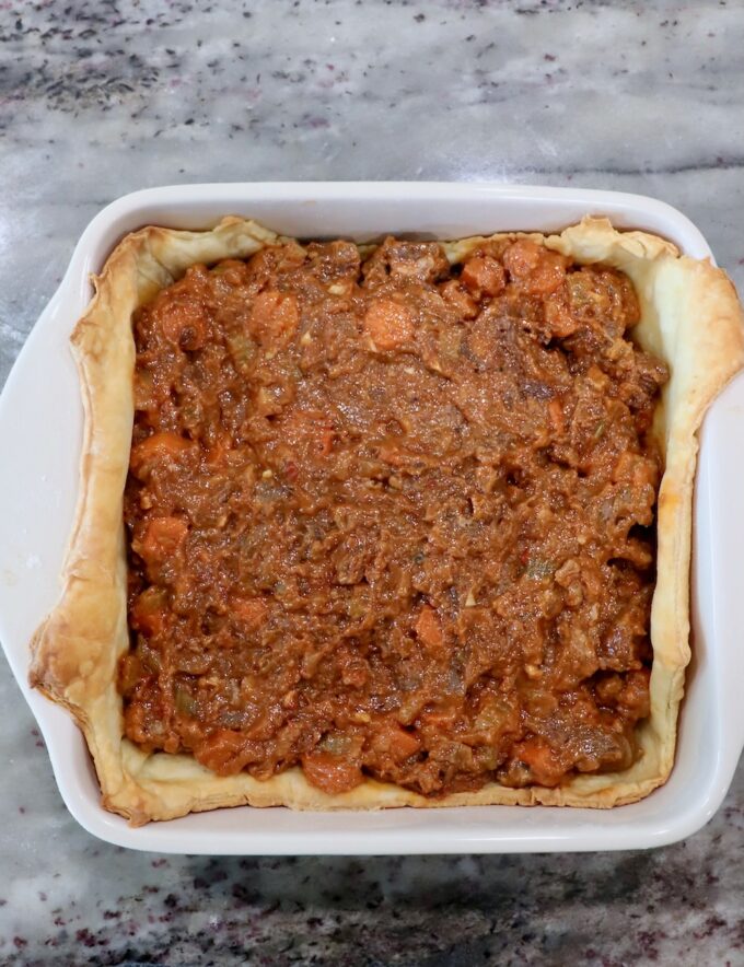 beef filling in a baked puff pastry crust in a baking dish