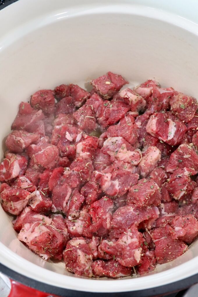 cubes of raw beef chuck roast in a cast iron dutch oven