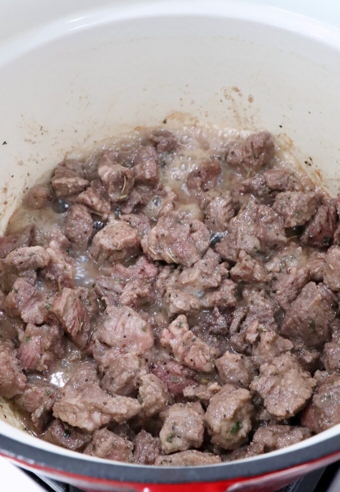 cubes of browned beef chuck roast in a cast iron dutch oven