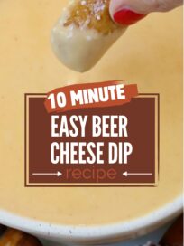 beer cheese dip in bowl with hand holding pretzel bite dipped in the cheese dip