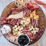 charcuterie board filled with meats, cheeses, crackers and fruits