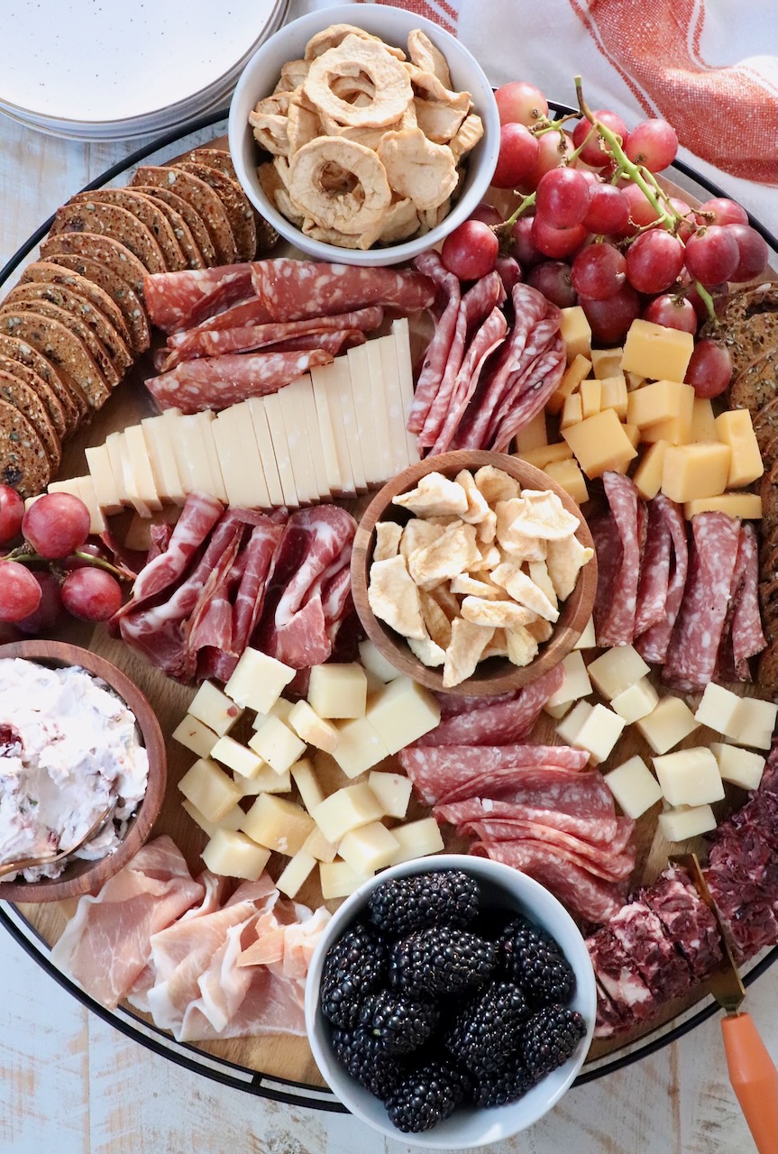 charcuterie board with cured meats, cheeses, fruits and crackers