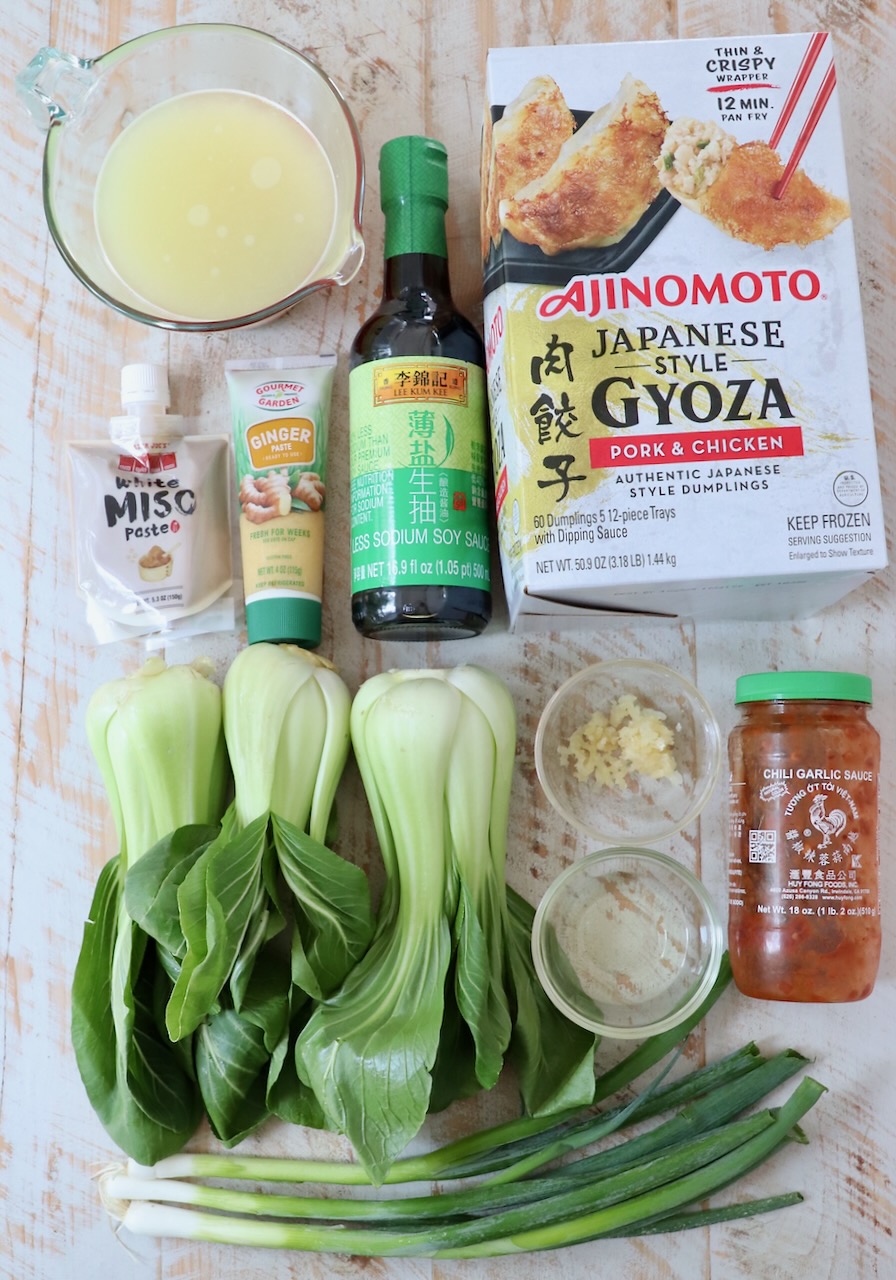 ingredients for gyoza soup on white wood board