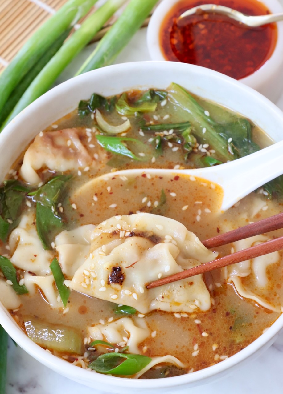 gyoza soup in bowl with chopsticks and spoon