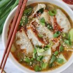 gyoza soup in bowl with chopsticks on the side