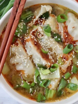 gyoza soup in bowl with chopsticks on the side