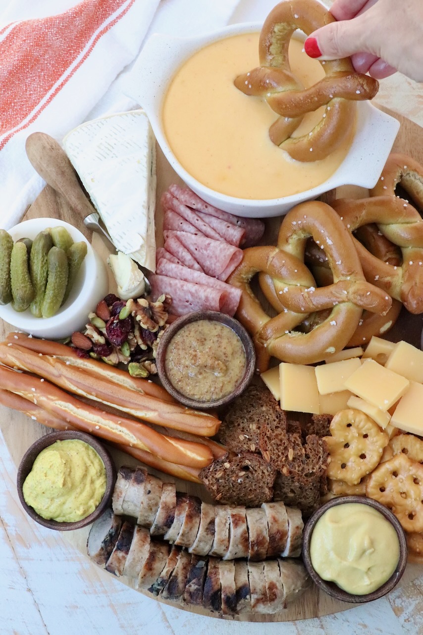 Oktoberfest charcuterie board with soft pretzel dipped in beer cheese dip