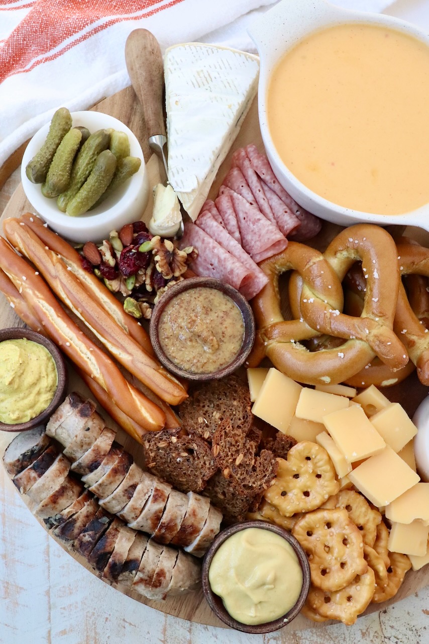 charcuterie board with grilled sausage, cheeses and pretzels