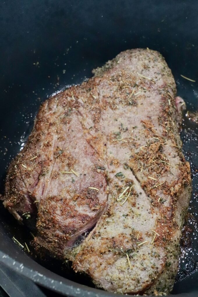 seared chuck roast in a large cast iron dutch oven