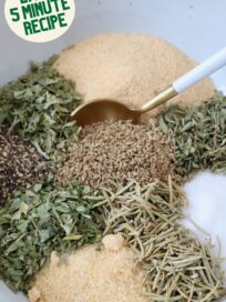 dried herbs and spices separated in a bowl with a spoon