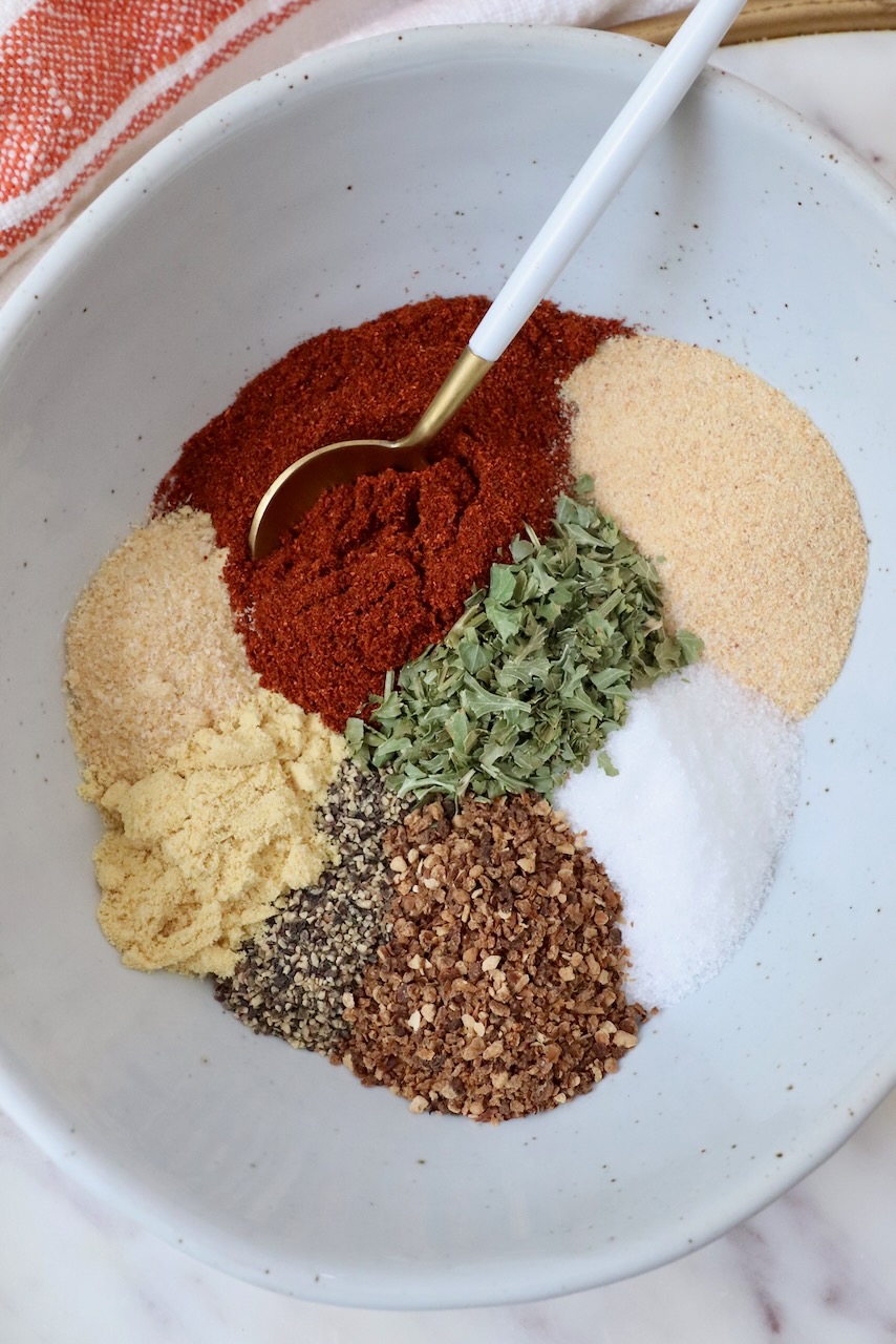 spices and herbs separated in a bowl with a spoon