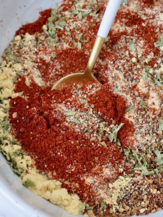 herbs and spices mixed together in a bowl with a spoon