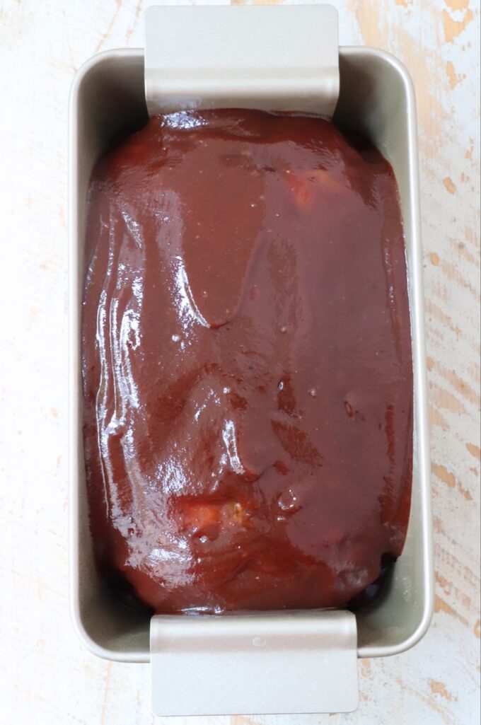 meatloaf topped with bbq sauce in a loaf pan