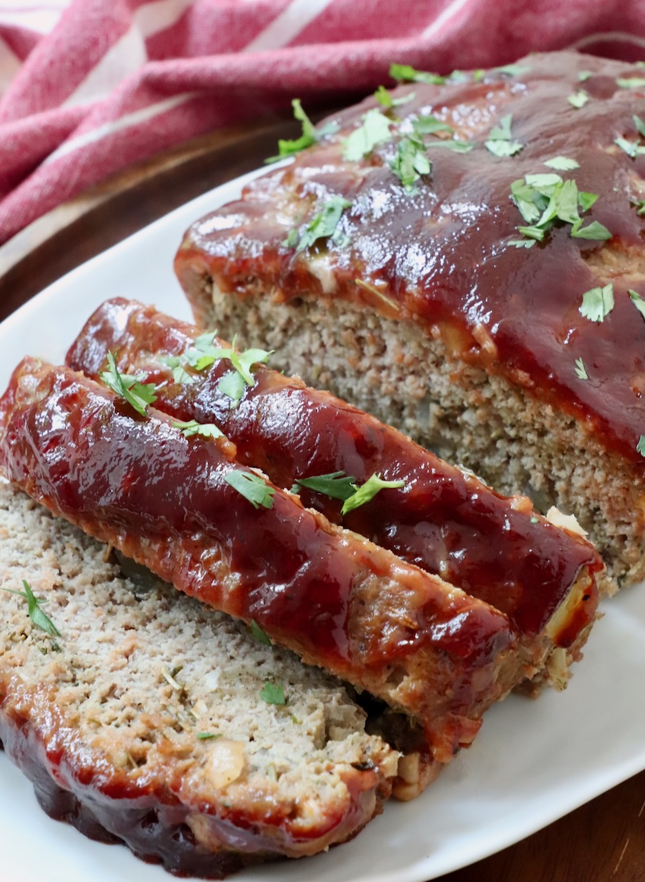 meatloaf glazed with bbq sauce sliced on a plate