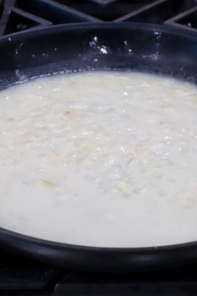 diced onions and garlic in a skillet with flour and broth