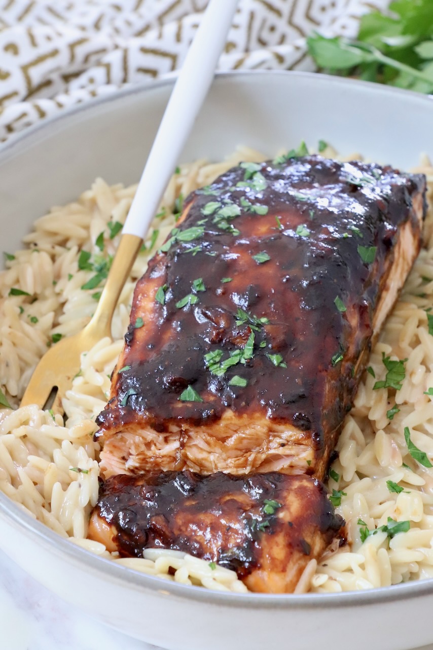 cooked balsamic glazed salmon on a bed of orzo in a bowl with a fork